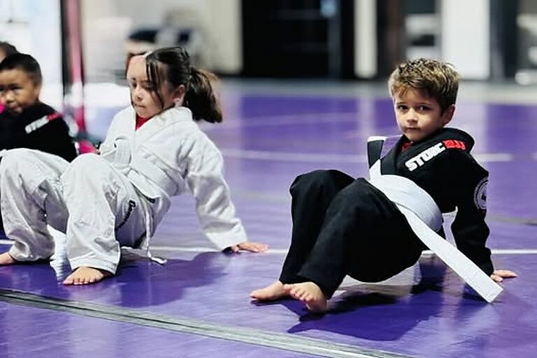 Kids shrimping down the mat during the warm-up at a jiu jitsu class in Mansfield, TX